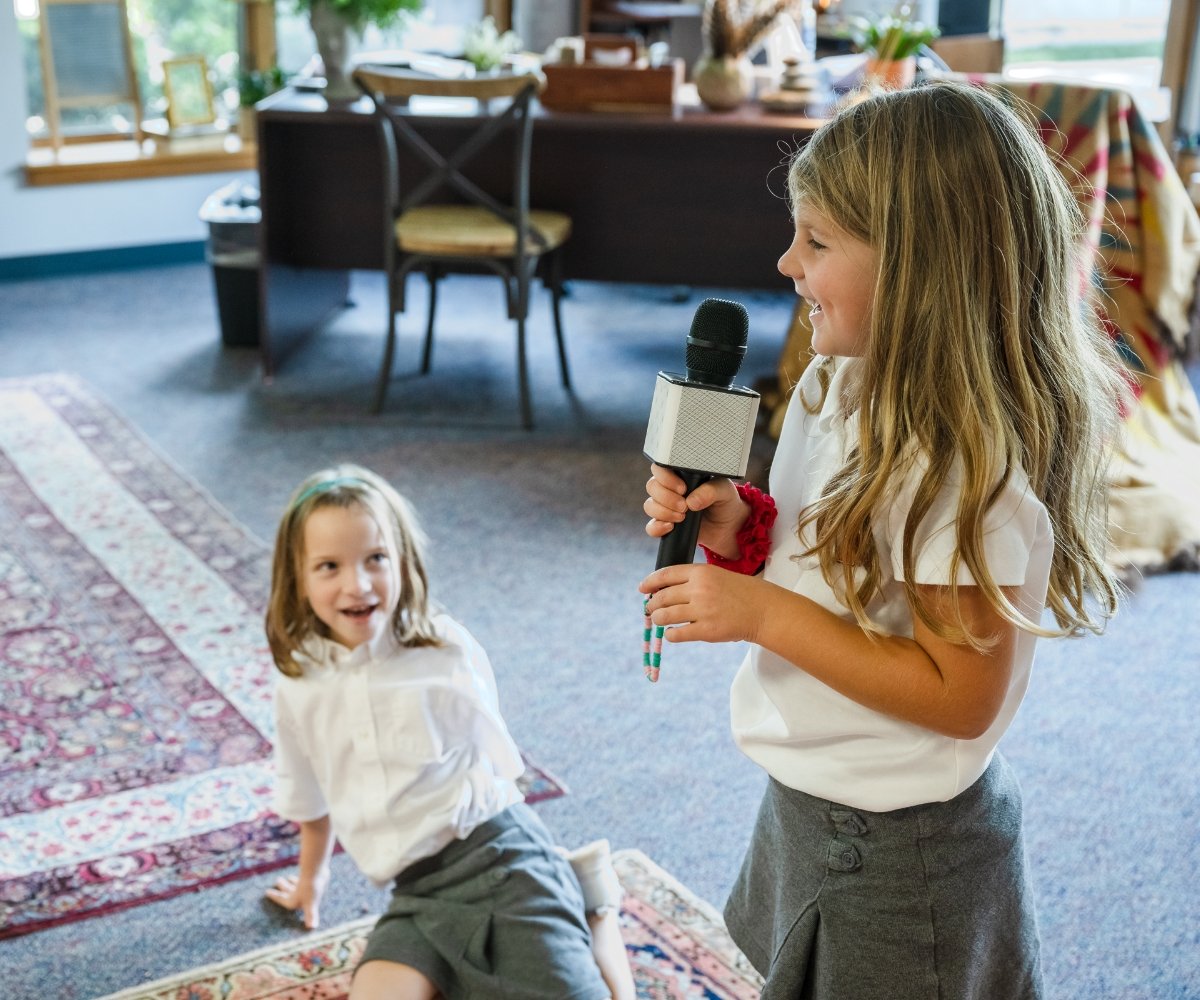 lower school student singing into microphone