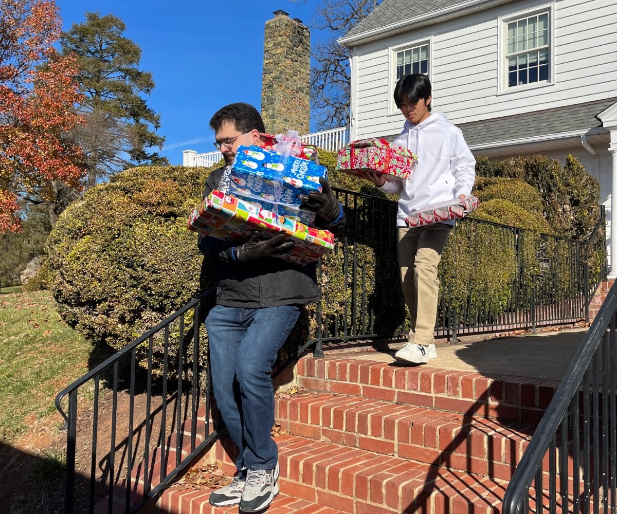 students bringing Christmas gifts down stairs