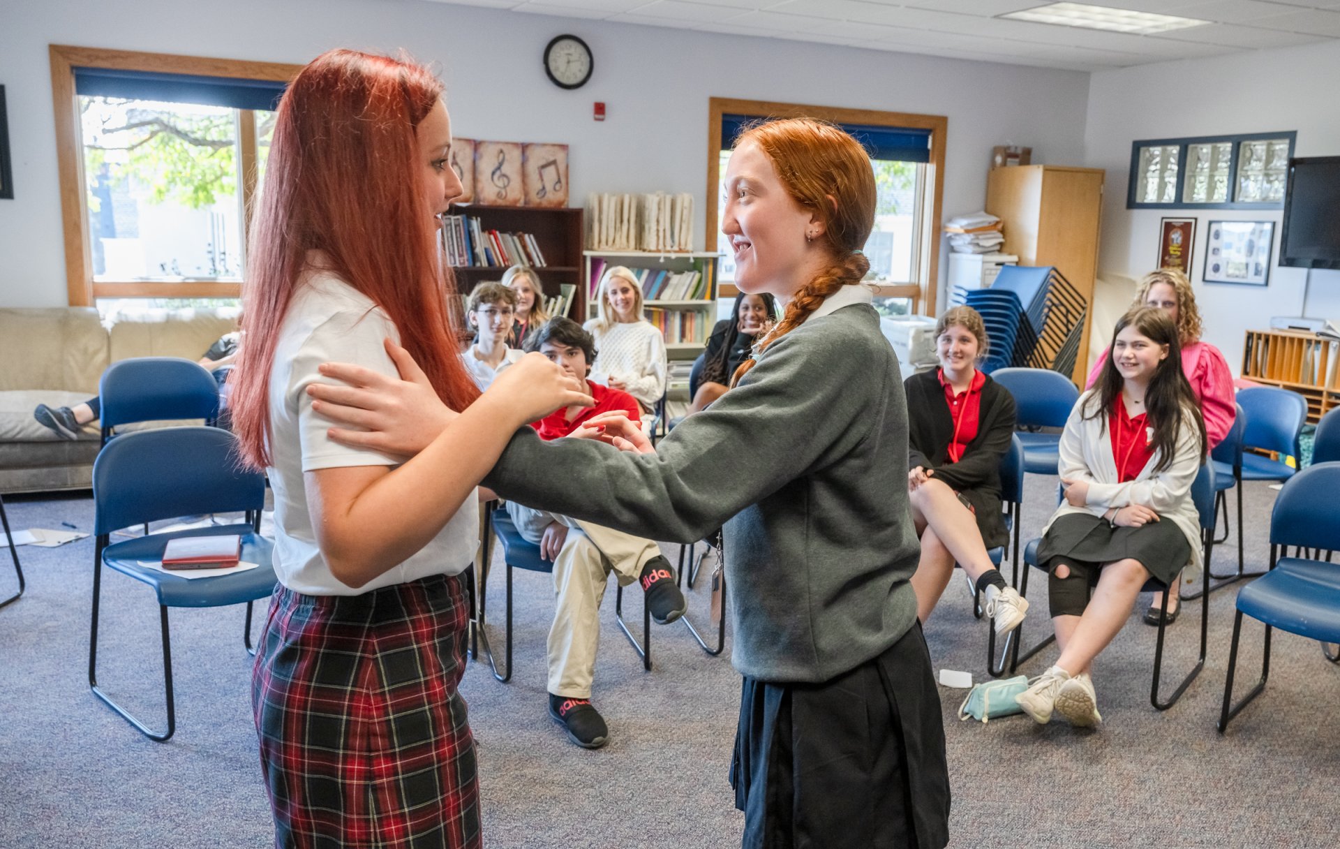 Two Middle School girls embrace as they act out a scene in Theater class