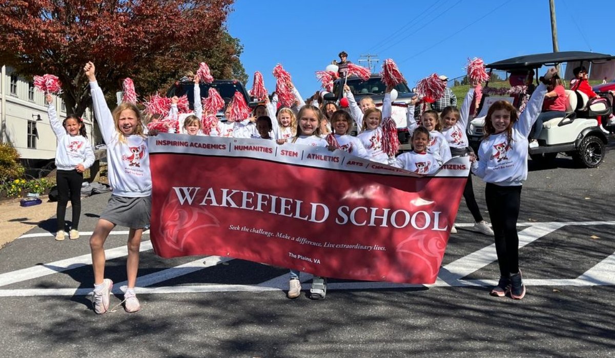 group of Wakefield cheerleaders outside with a Wakefield School banner