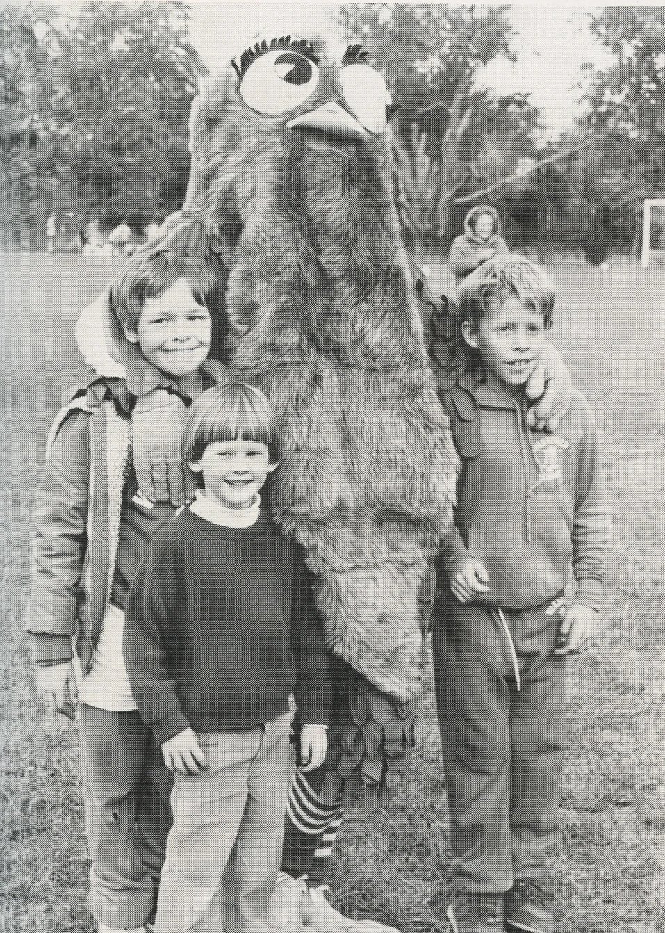 students posing with old owl mascott