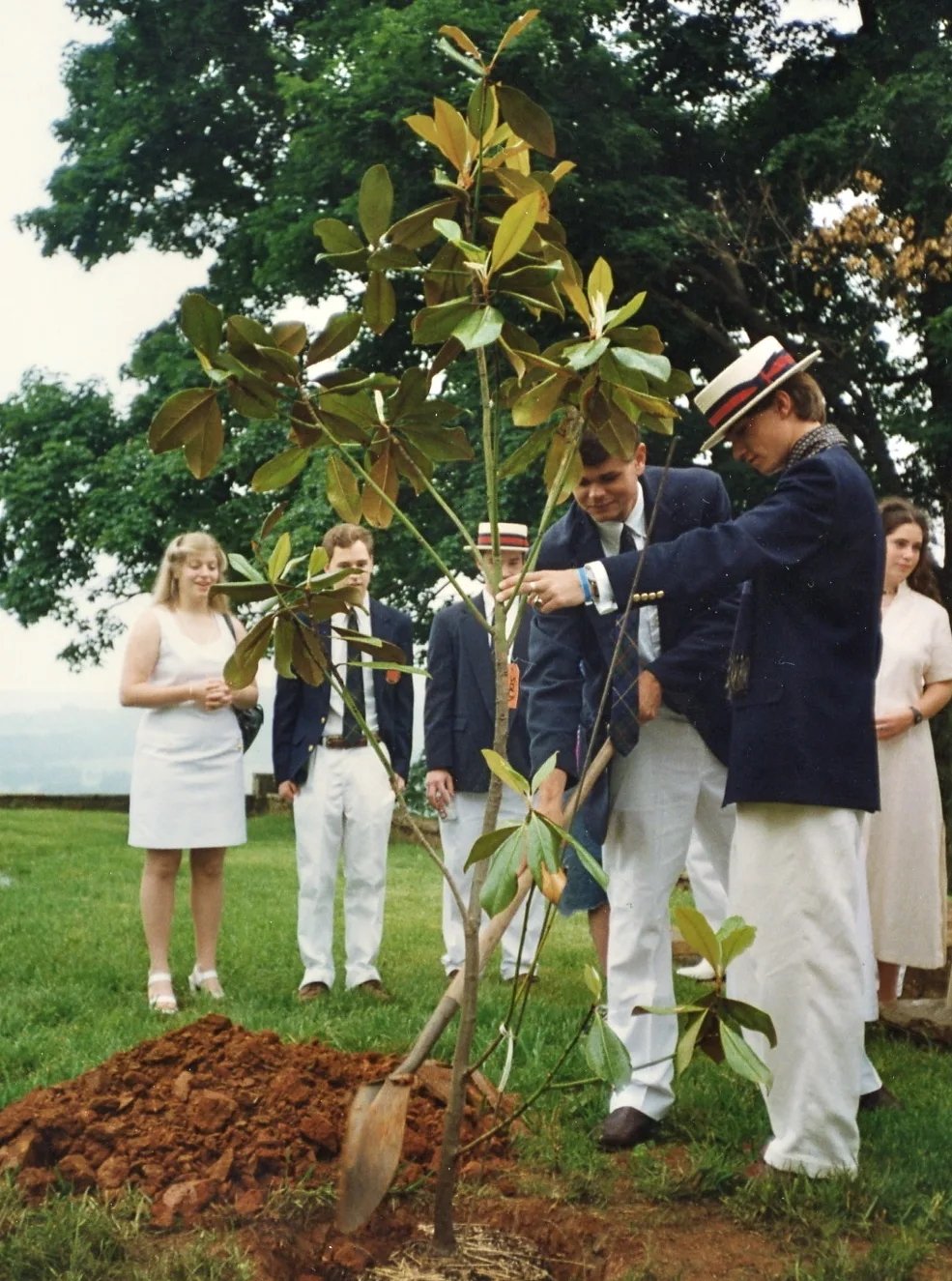 students planting a tree during graduation ceremony