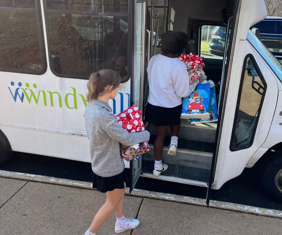 students loading Christmas gifts onto a bus