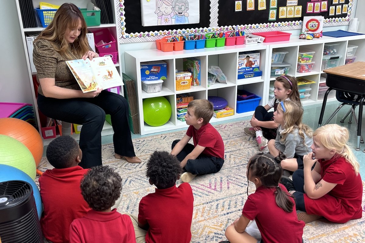 lower school teacher reading a book to students