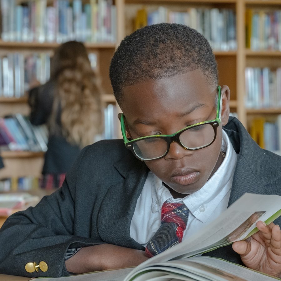 student in library reading a book
