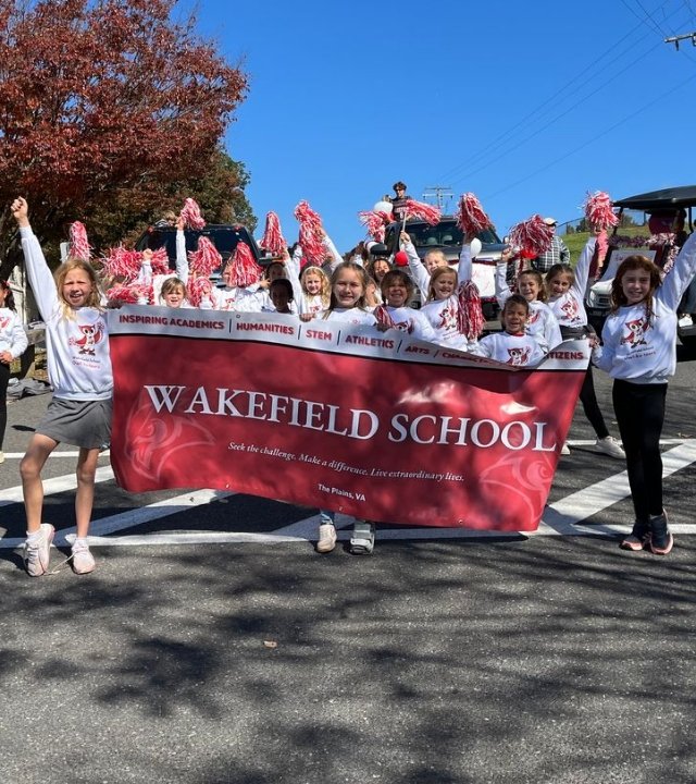 group of Wakefield cheerleaders holding a school banner