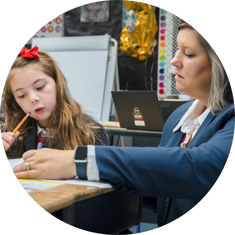 teacher and lower school student working on an assignment